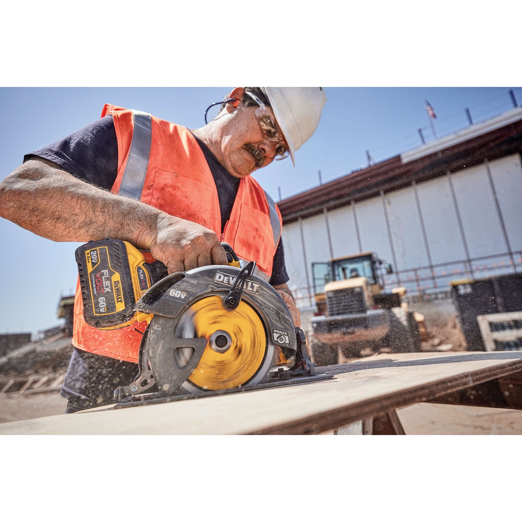DEWALT DCB609 battery in use with a circular saw by a worker wearing an orange safety vest at a construction site.