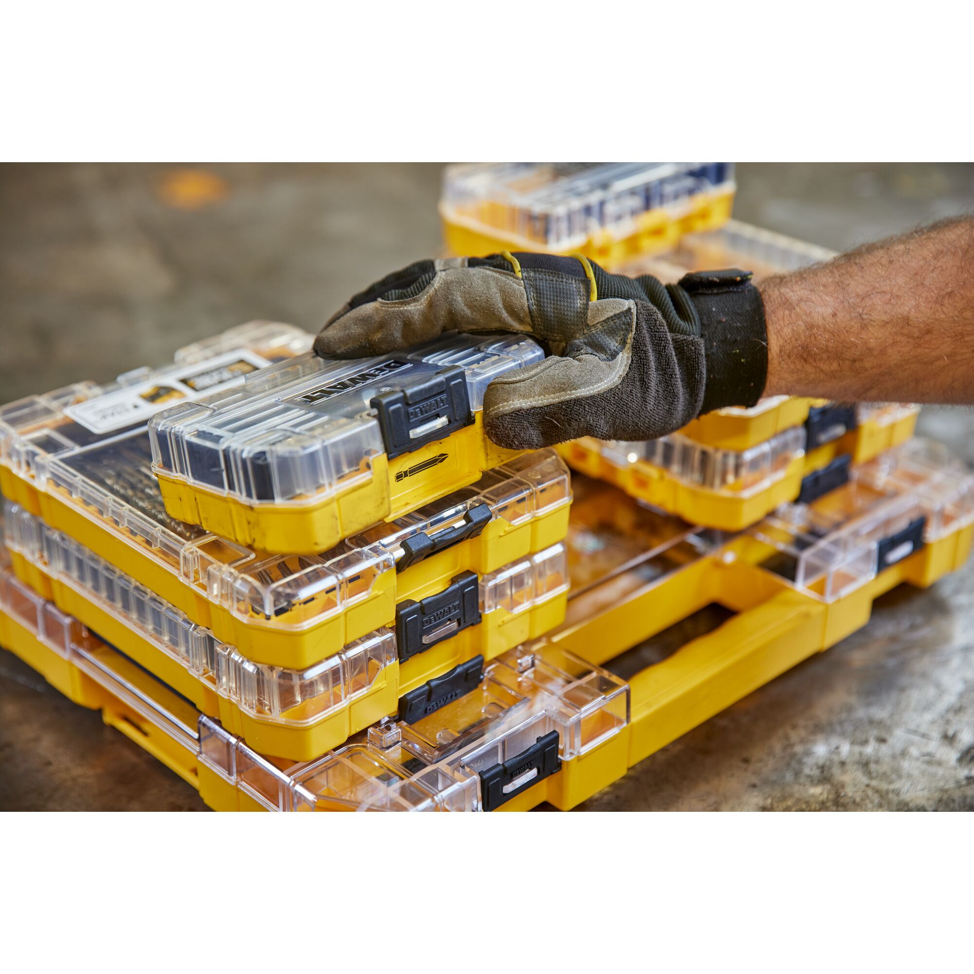 overhead back shot user with their hand on DEWALT 40 Piece Impact Screwdriver Bit Set with closed case lid and out the pack