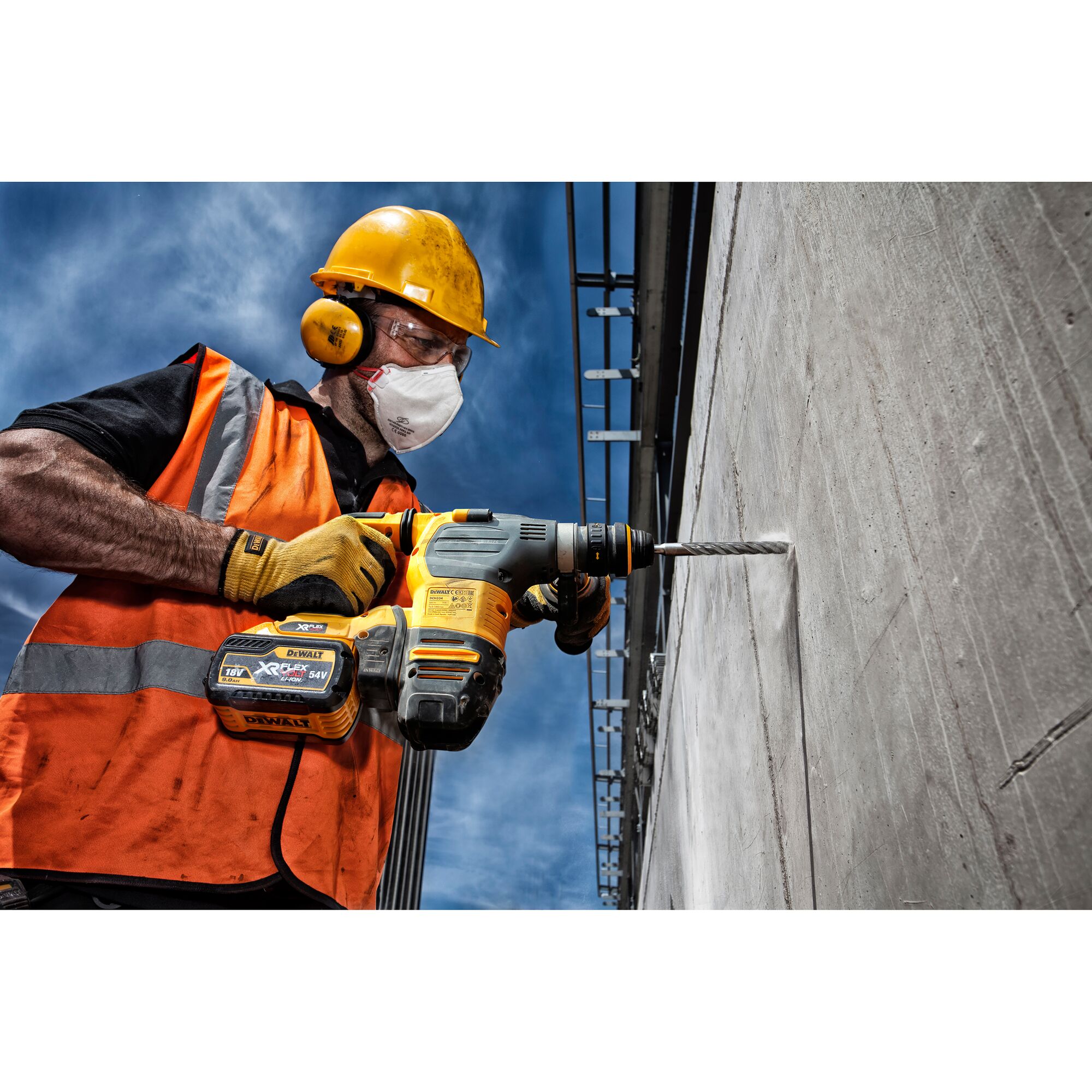 DEWALT DT9580, DT9580-QZ drill in use on concrete wall by a worker in safety gear. Photography category.