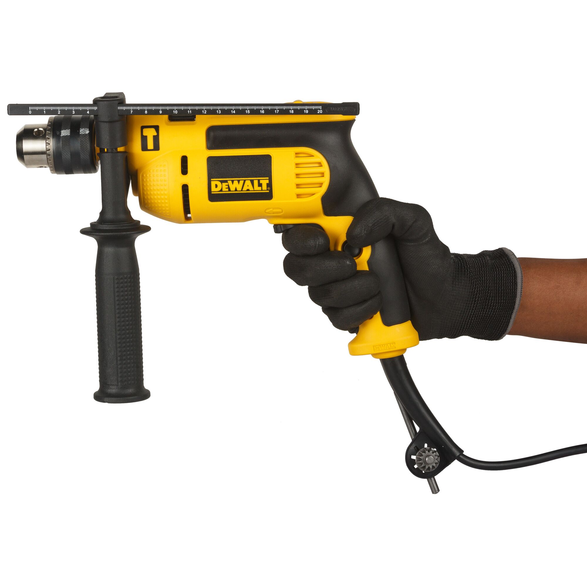 A person wearing a black glove is holding a yellow and black DEWALT electric drill with an auxiliary handle and depth gauge, model DWD024, against a white background.
