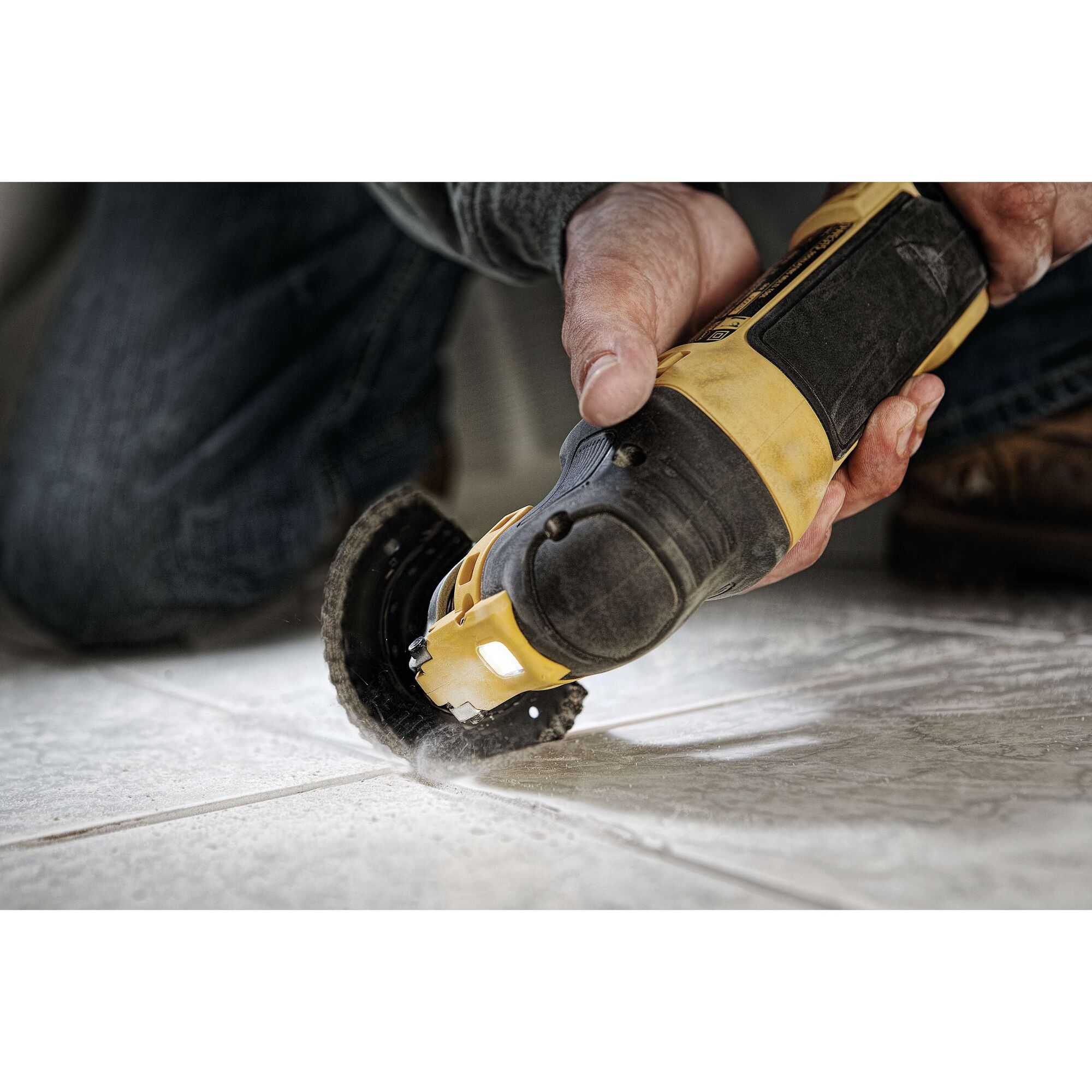 Oscillating multi tool kit being used to cut tile.